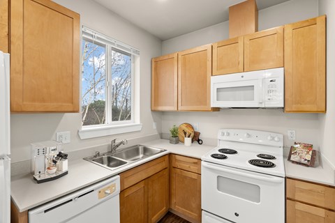 A kitchen with wooden cabinets and white appliances.