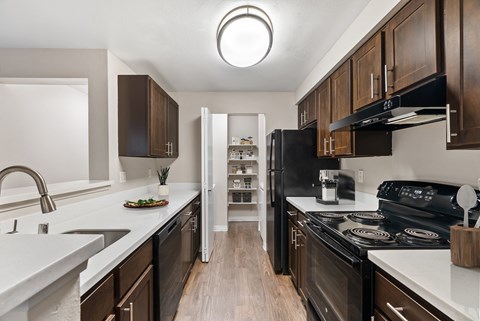 A modern kitchen with dark wood cabinets and white countertops.