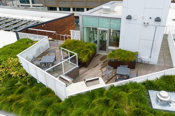 A rooftop patio with a table and chairs.