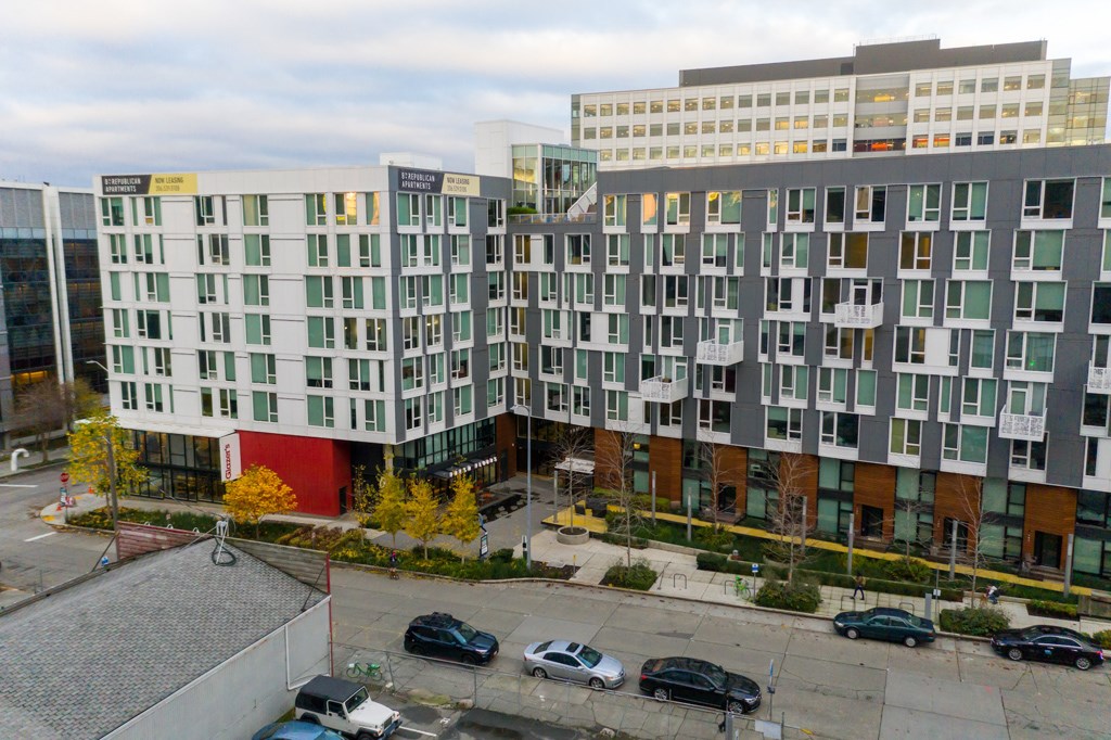 A parking lot with cars and apartment buildings.