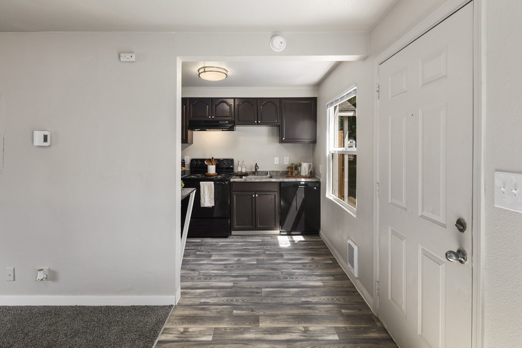 A kitchen with a white door and a black counter.