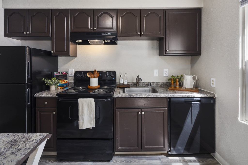 A kitchen with a black stove top oven and black appliances.