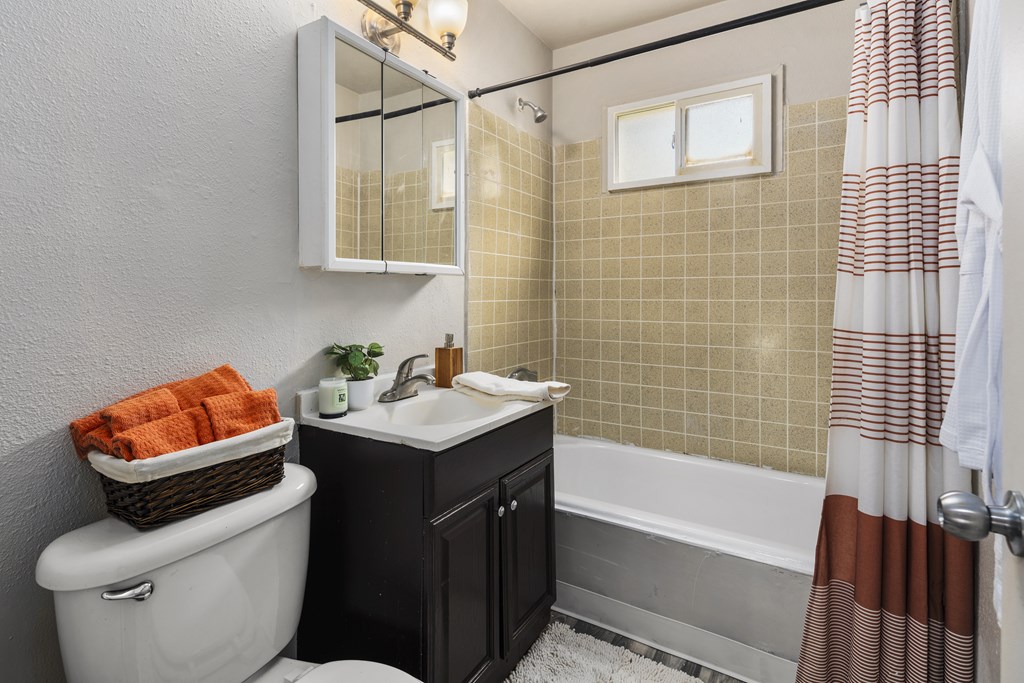 A bathroom with a white toilet, a sink, and a bathtub.