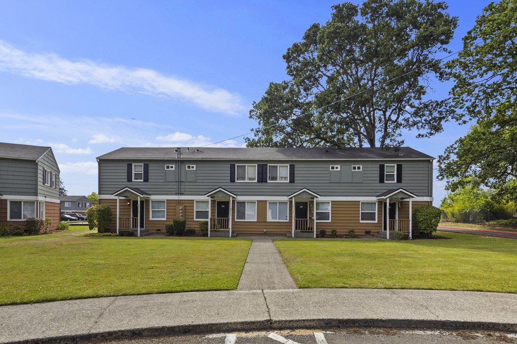 A row of houses with a tree in the back.