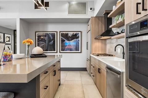 A modern kitchen with a stainless steel oven and wooden cabinets.