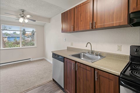 A kitchen with brown cabinets and a black stove top oven.