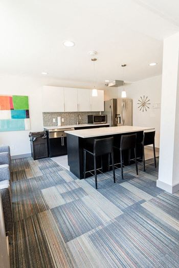 an open kitchen and living room with a bar and chairs at Cadence, Washington