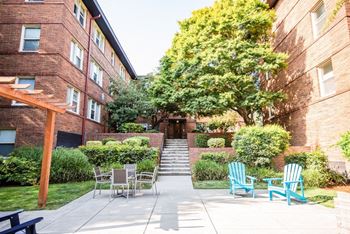 a patio with chairs and tables in front of a brick building at Cadence, Washington, 98107
