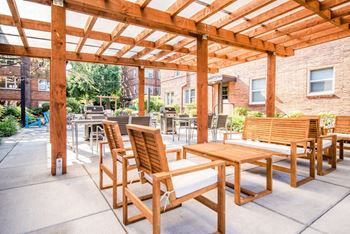 a patio with wooden tables and chairs and a pergola at Cadence, Seattle, 98107