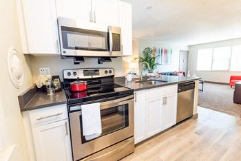 a kitchen with stainless steel appliances and white cabinets at Cadence, Seattle, Washington