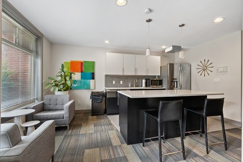 A modern kitchen with black bar stools and a white countertop.