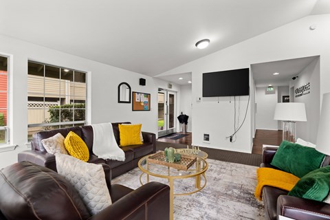 A living room with a brown leather couch and a glass coffee table.