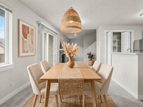 A dining room with a wooden table and chairs.