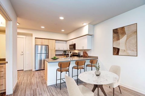 A modern kitchen with a dining table and chairs.