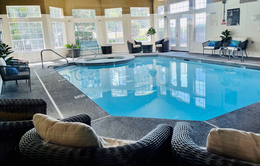 a large indoor pool with chairs and windows in the background  at Monterra, Tacoma