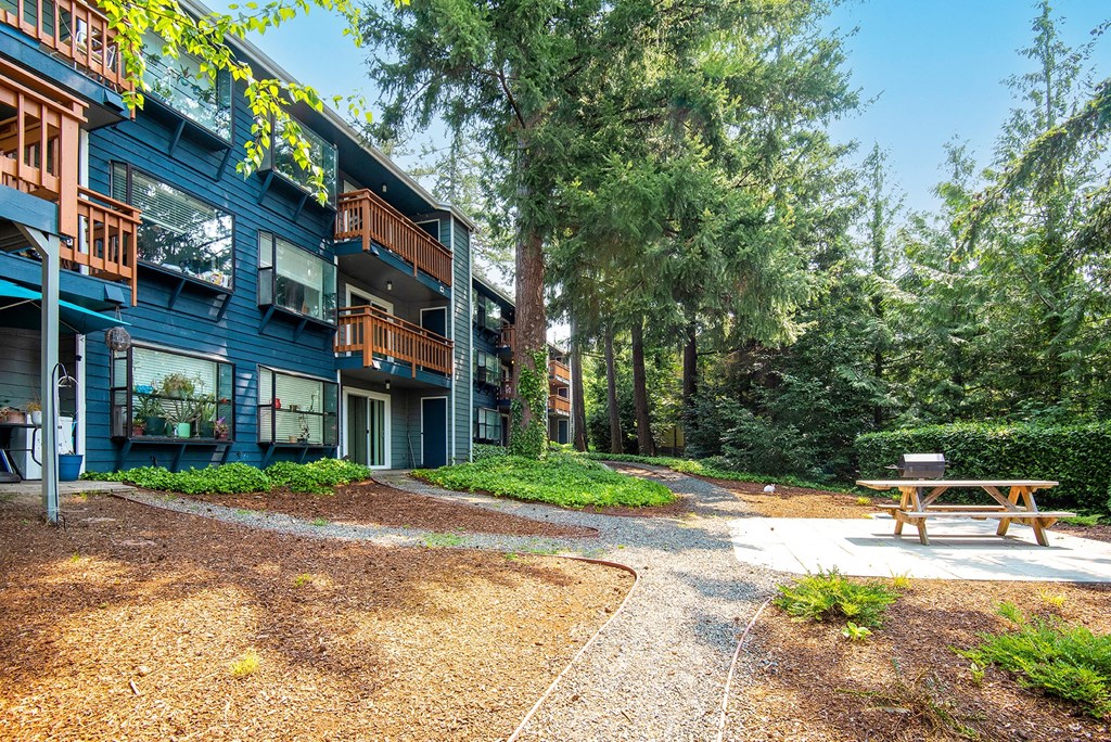 a picnic table sits in front of a blue building