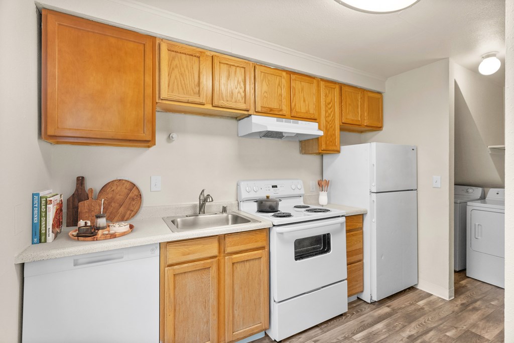 A kitchen with wooden cabinets and white appliances.