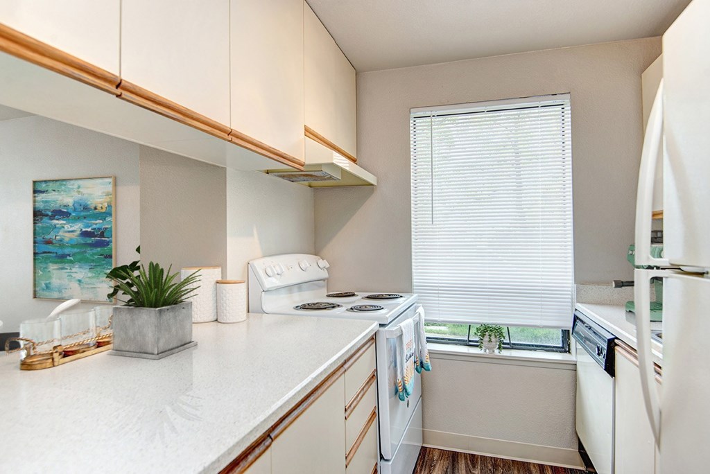 A kitchen with white appliances and a white counter top.