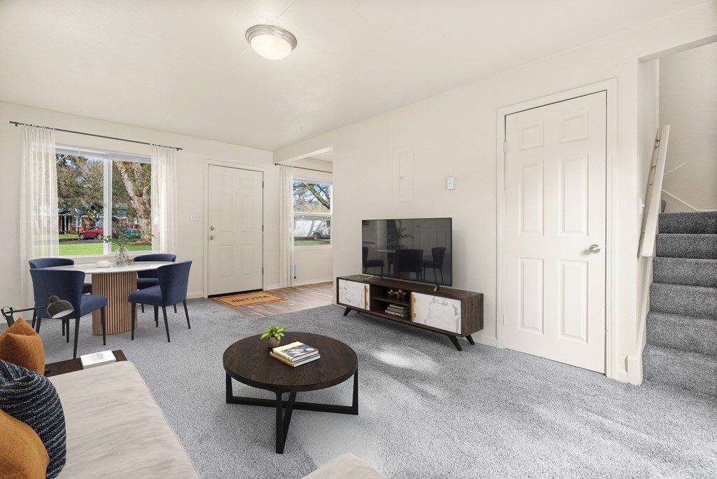 A living room with a television, chairs, and a coffee table.
