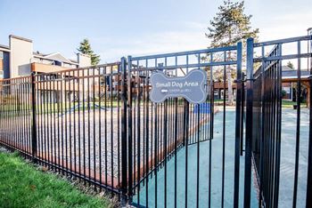 A black fence surrounds a small dog area. at Northpoint Apartments, Tacoma, Washington