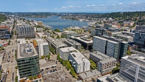 A cityscape with buildings and a body of water in the background.