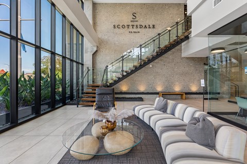 A modern interior space with a glass table and a staircase.