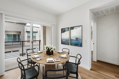 A dining room with a table set for six people.