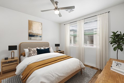 A bedroom with a large bed and a ceiling fan.