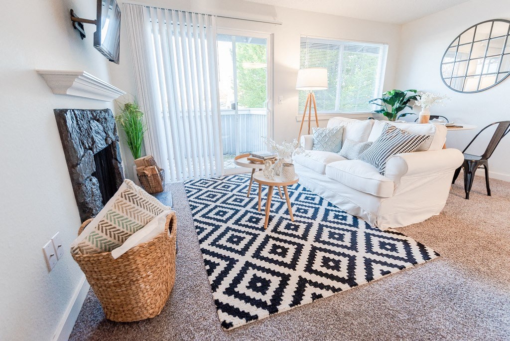 living room with couch and tv with balcony view at ReVive Apartments, Fife, WA