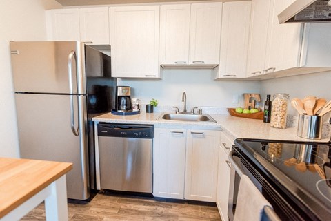 a kitchen with stainless steel appliances and white cabinets