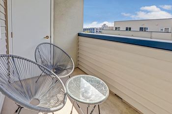 a private balcony with two chairs and a table