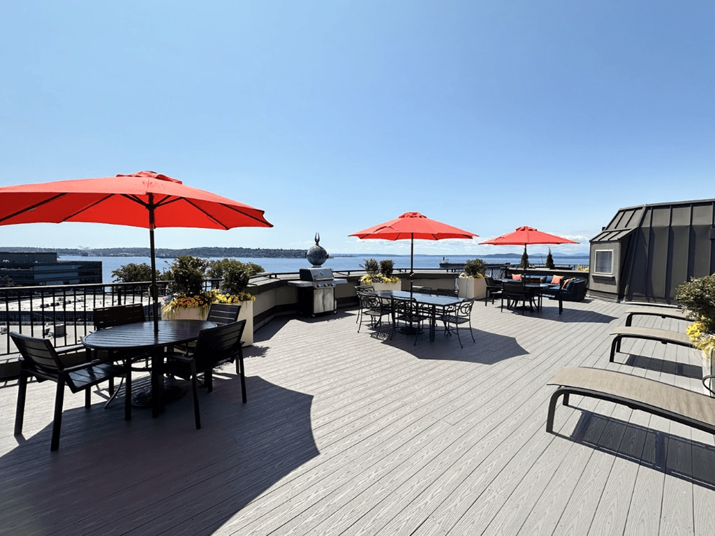 A patio with tables and chairs and umbrellas.