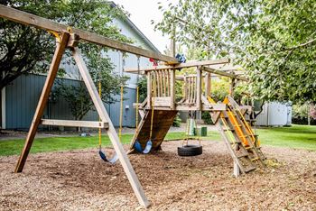 A wooden swing set with a slide and a tire swing. at The Retreat, Sumner