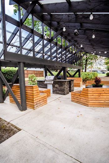 A wooden deck with a glass roof and a concrete floor. at The Retreat, Washington, 98390
