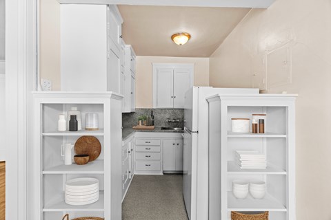 A kitchen with white cabinets and a countertop with a sink.