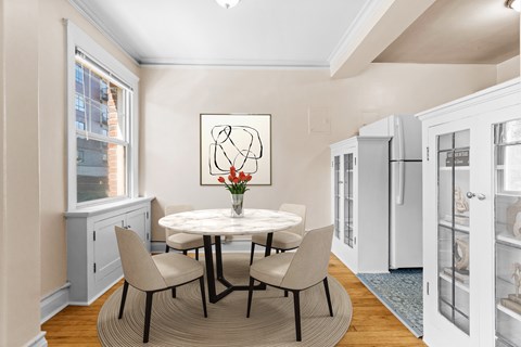 A dining room with a white table and chairs.