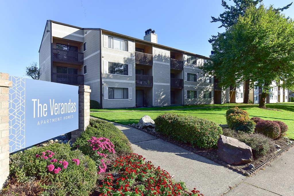 The Verandas Apartment Homes building with a blue sign in front of it.