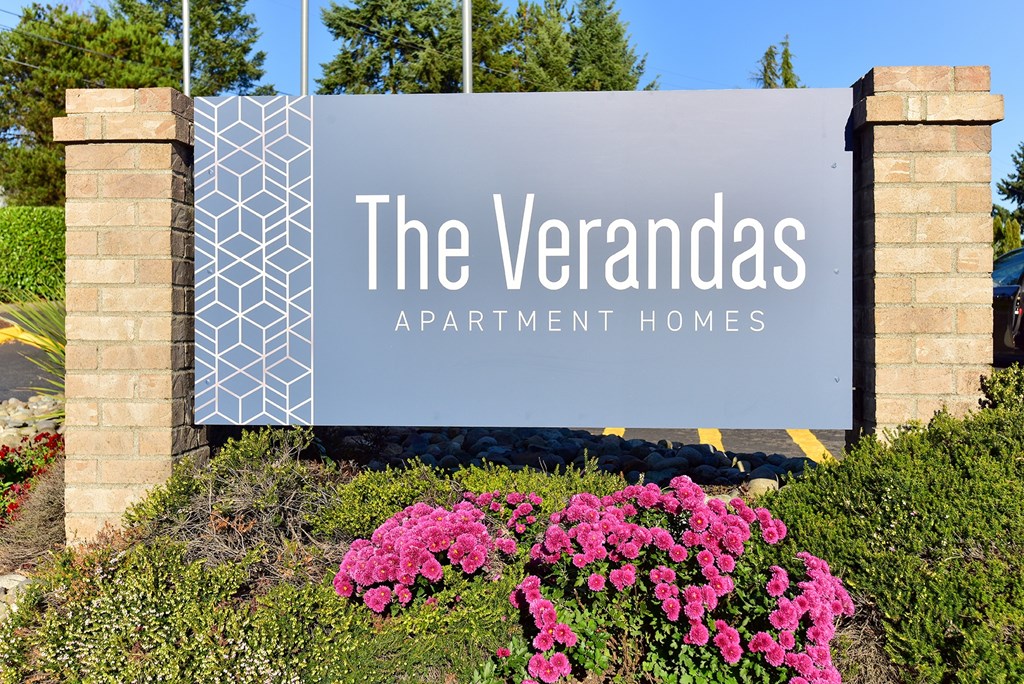 A sign for The Verandas Apartment Homes is displayed in front of a building.