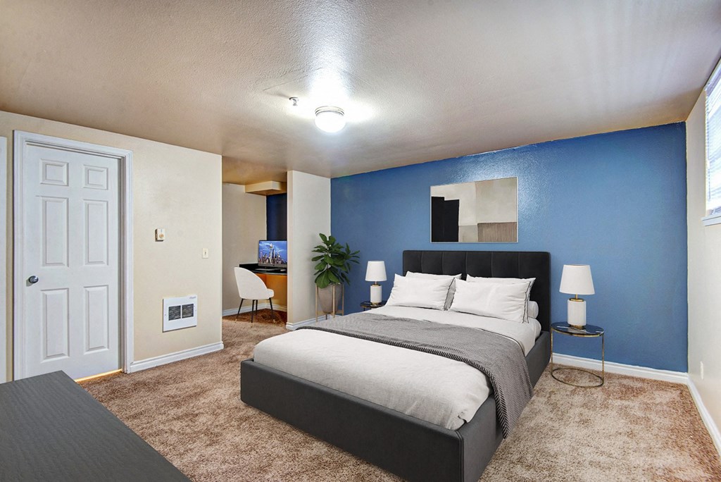 a bedroom with a bed and a blue wall at Ellis Court Apartments, Washington, 98121