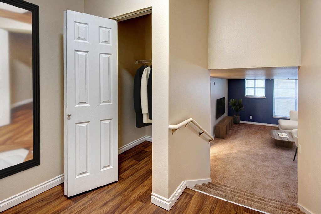 an open door leading into a living room with a mirror and a closet at Ellis Court Apartments, Seattle, 98121