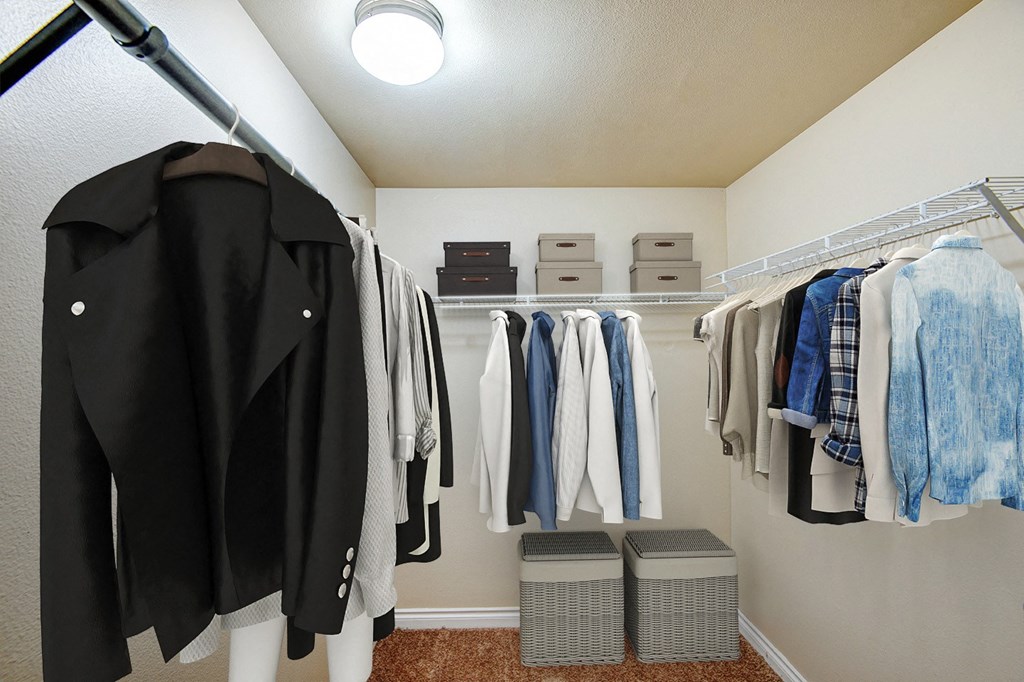 a wardrobe with clothes hanging on a rack in a closet at Ellis Court Apartments, Seattle, WA, 98121