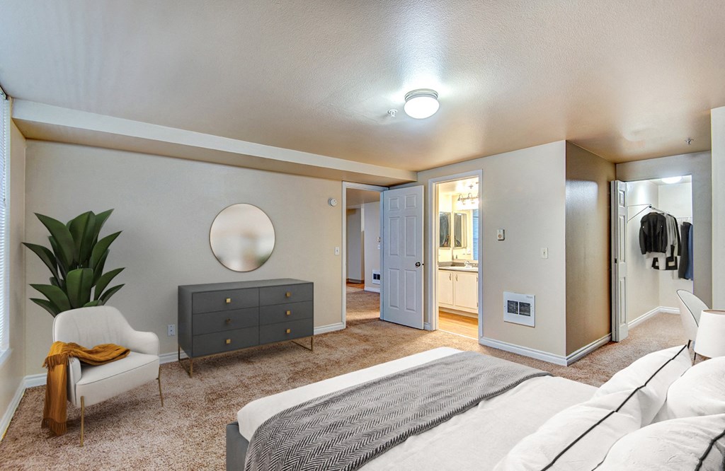 a bedroom with a bed and a dresser and a bathroom at Ellis Court Apartments, Washington