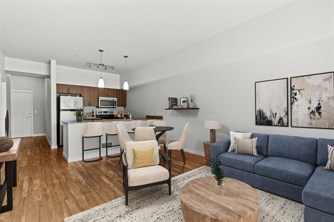 A modern living room with a blue couch and a dining table.