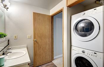a washer and dryer in a laundry room with a door to the bathroom