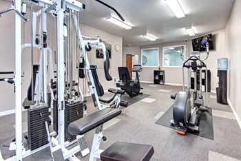 a gym with weights and cardio equipment at the enclave at university campuses