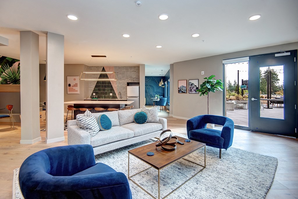 a living room with blue chairs and a couch at Hazel Apartments, Washington, 98026