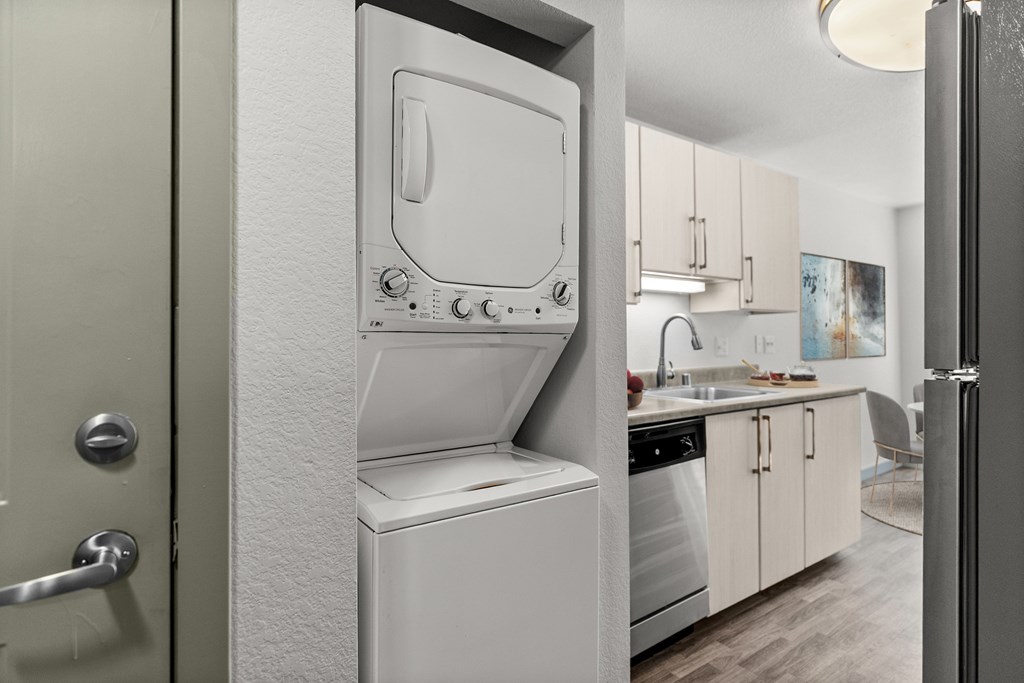 A white dishwasher is in a kitchen with a door open.