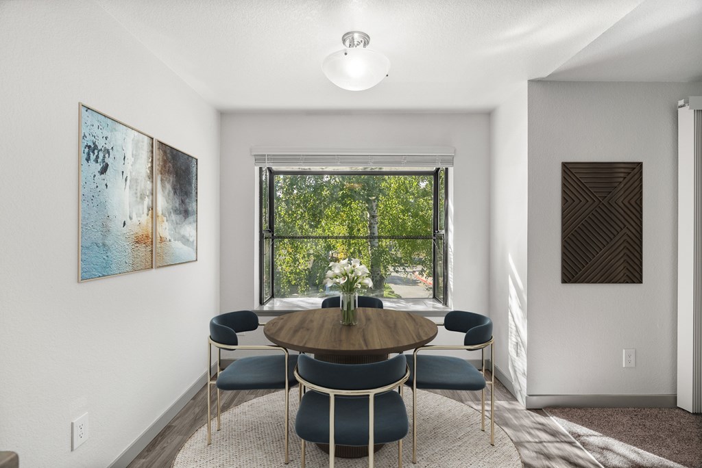 A dining room with a round table and chairs.