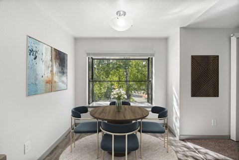 A dining room with a round table and chairs.