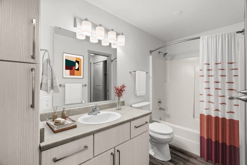 A bathroom with a white toilet, sink, and shower curtain.